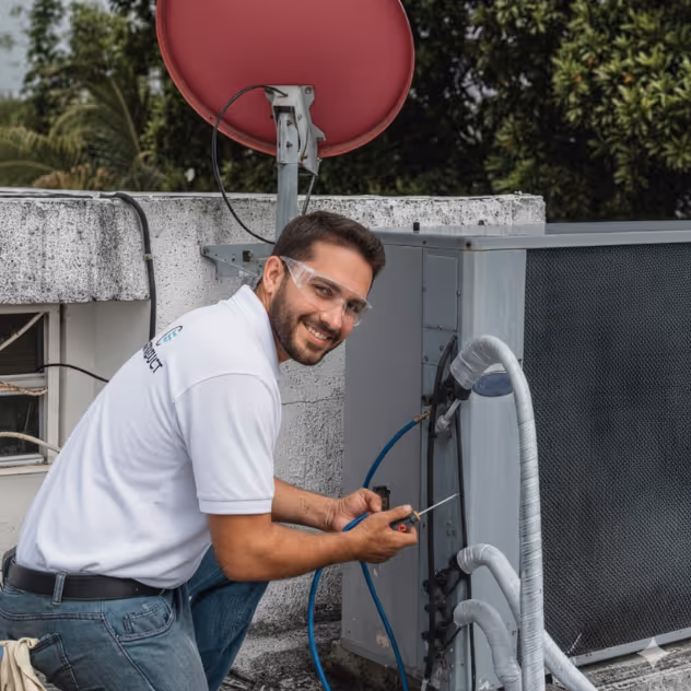 Floriduct technician servicing a residential AC condenser and air handler in South Florida