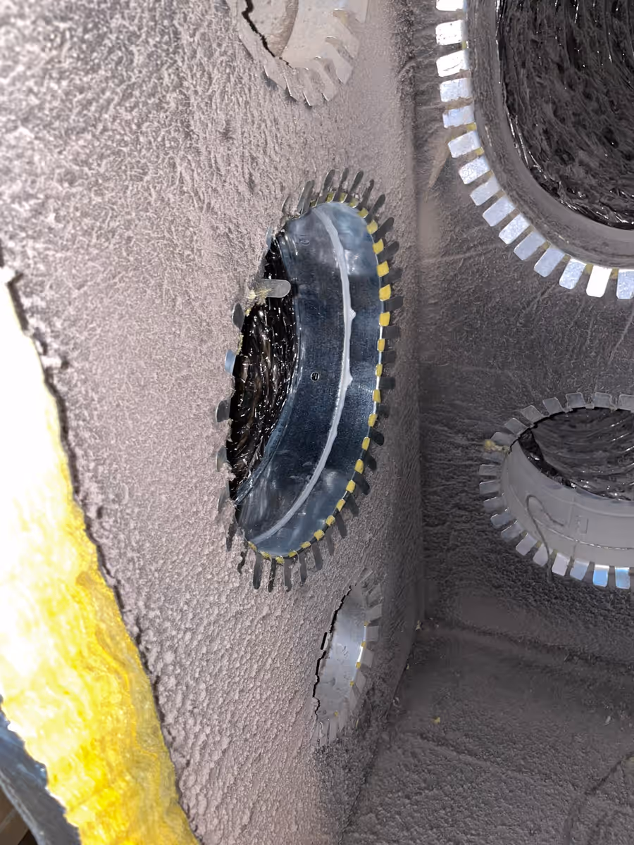 Dust-caked duct collars inside a return plenum before cleaning on a South Florida job