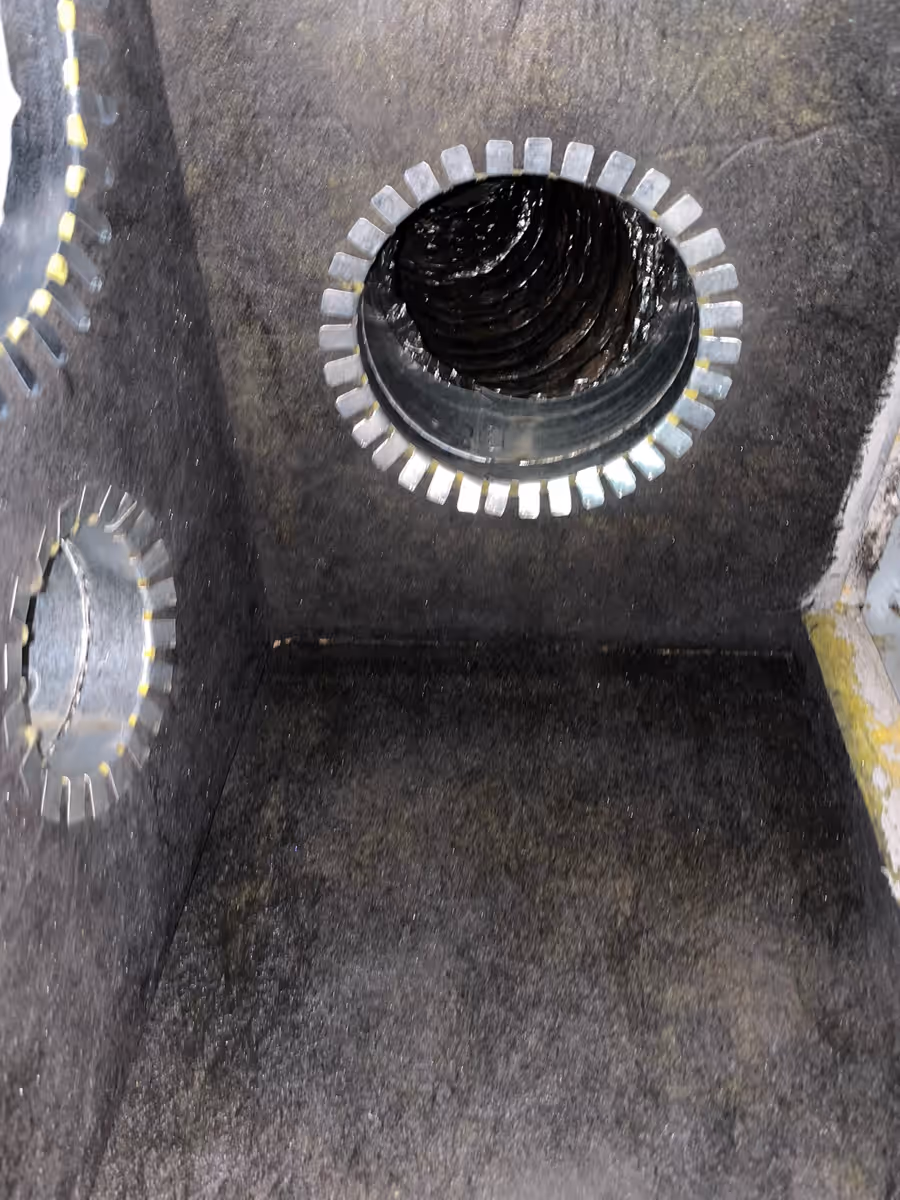 Flex duct opening behind a return vent in a South Florida home, lined with years of buildup