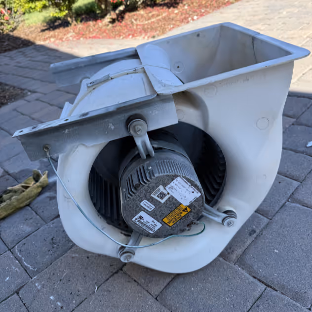 Blower fan assembly pulled out of an air handler and opened up for cleaning