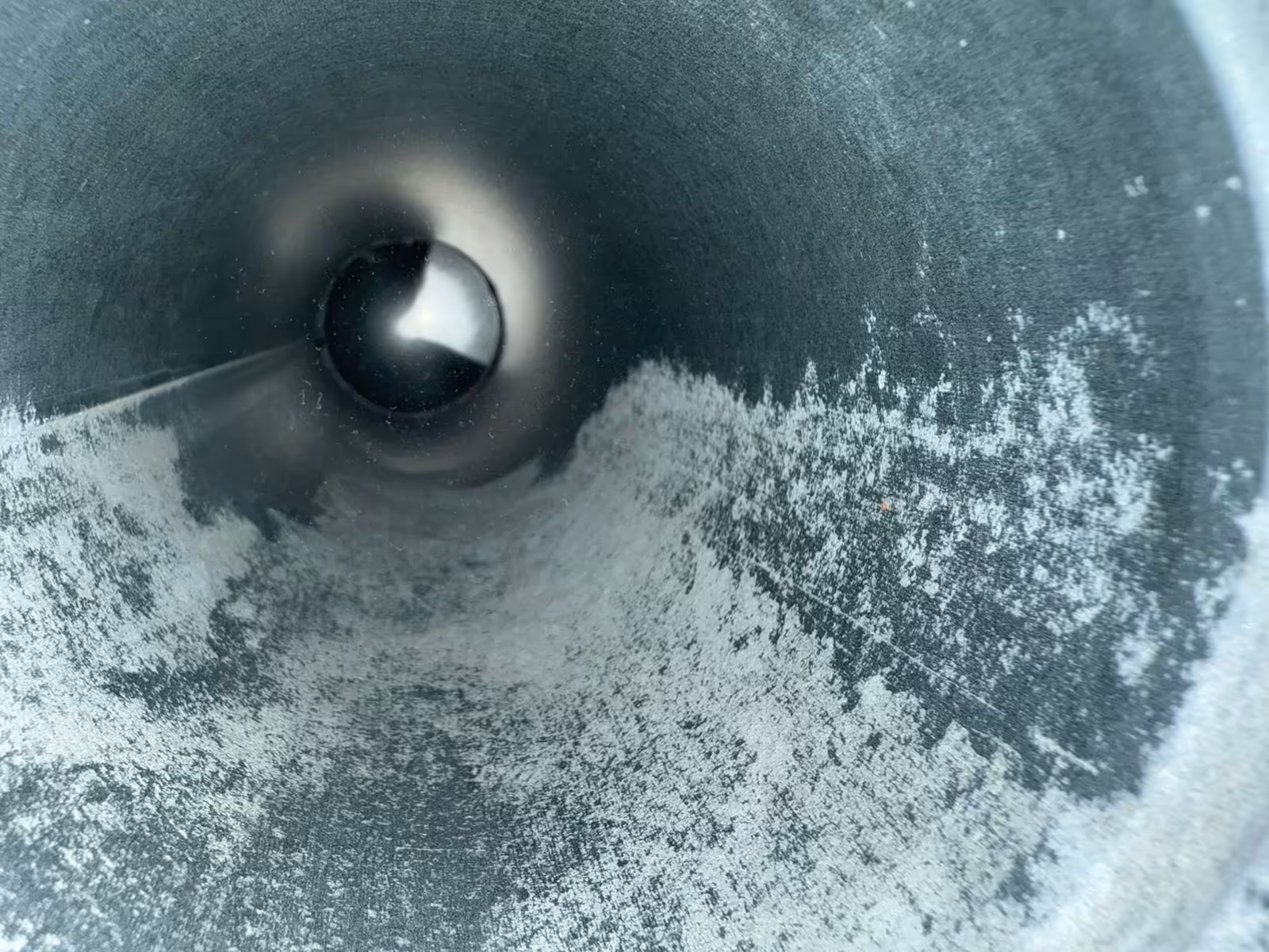 The same dryer vent pipe after cleaning, the wall back to bare metal with only light residue left