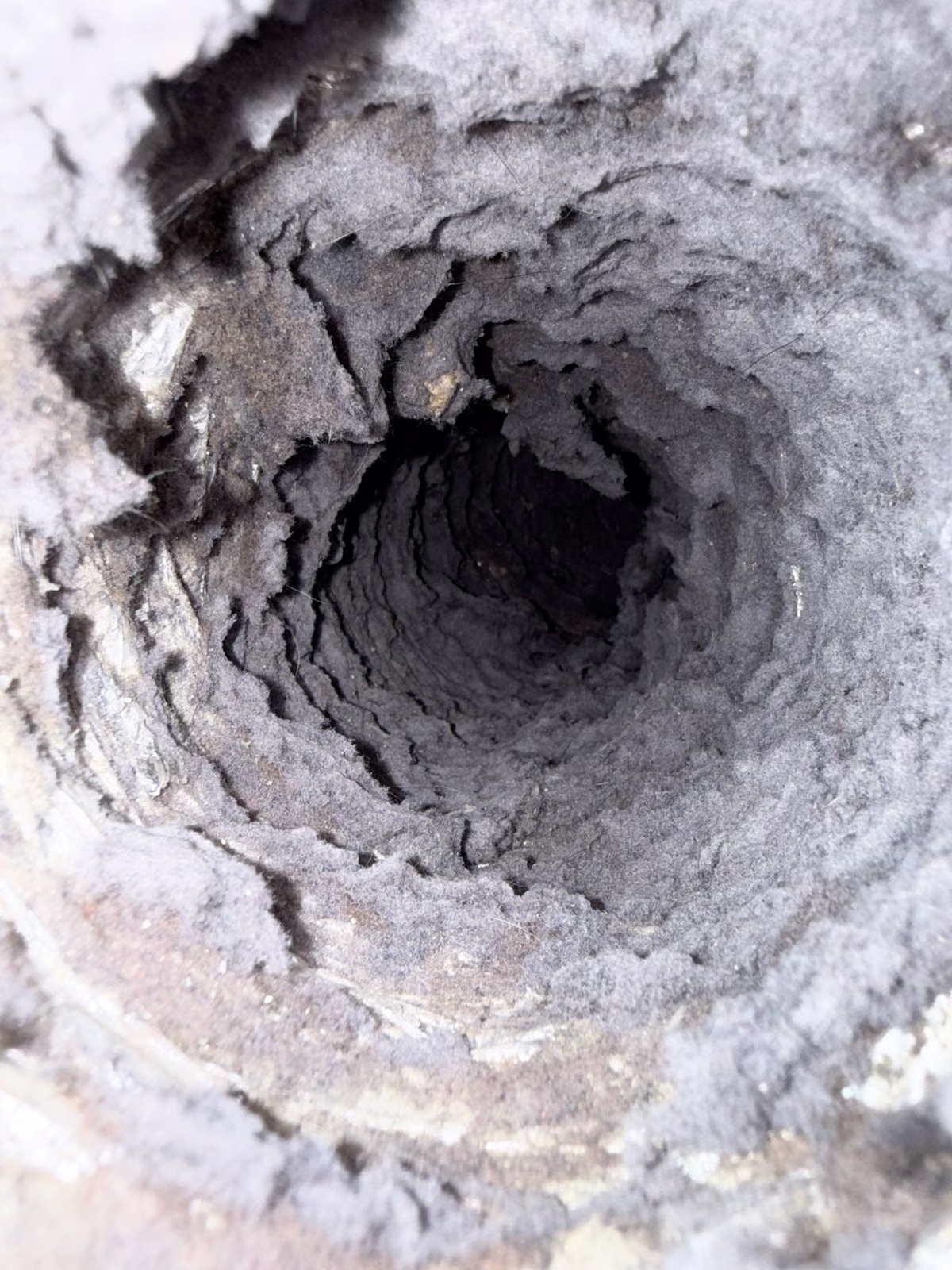 The inside of a dryer vent line lined with packed lint on a South Florida job
