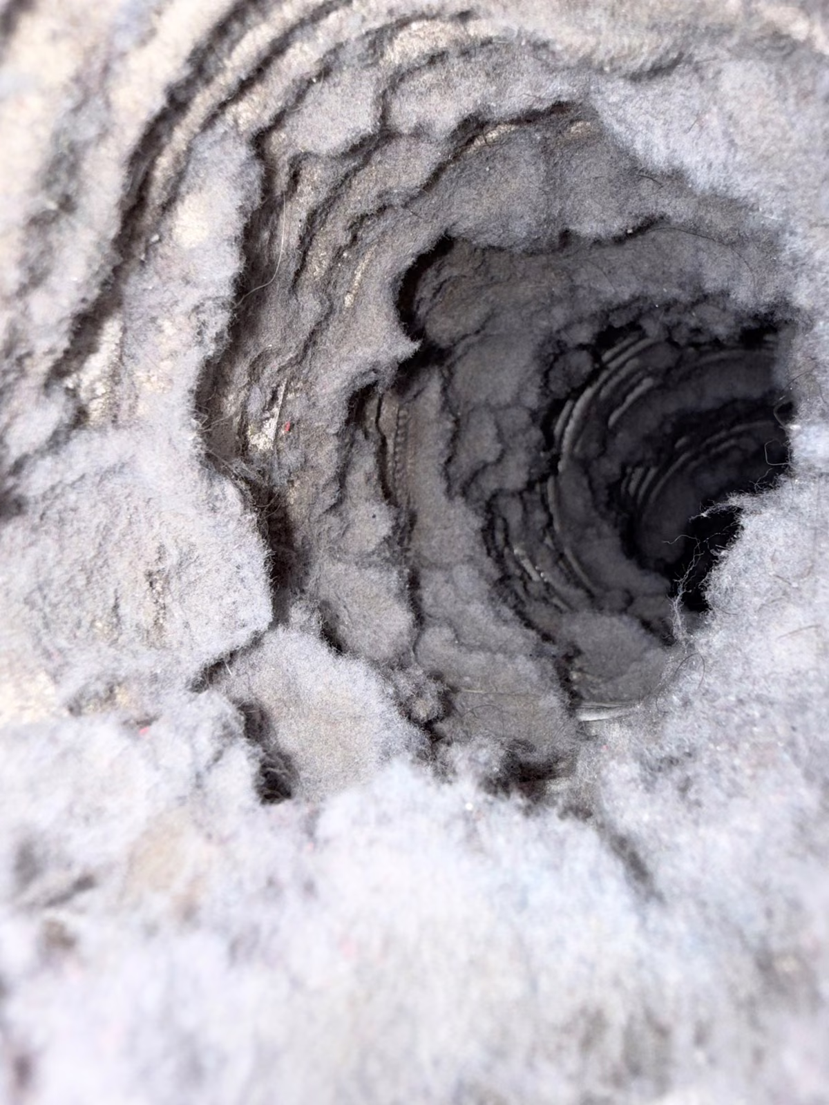 Looking into a dryer vent line packed almost shut with lint on a South Florida job