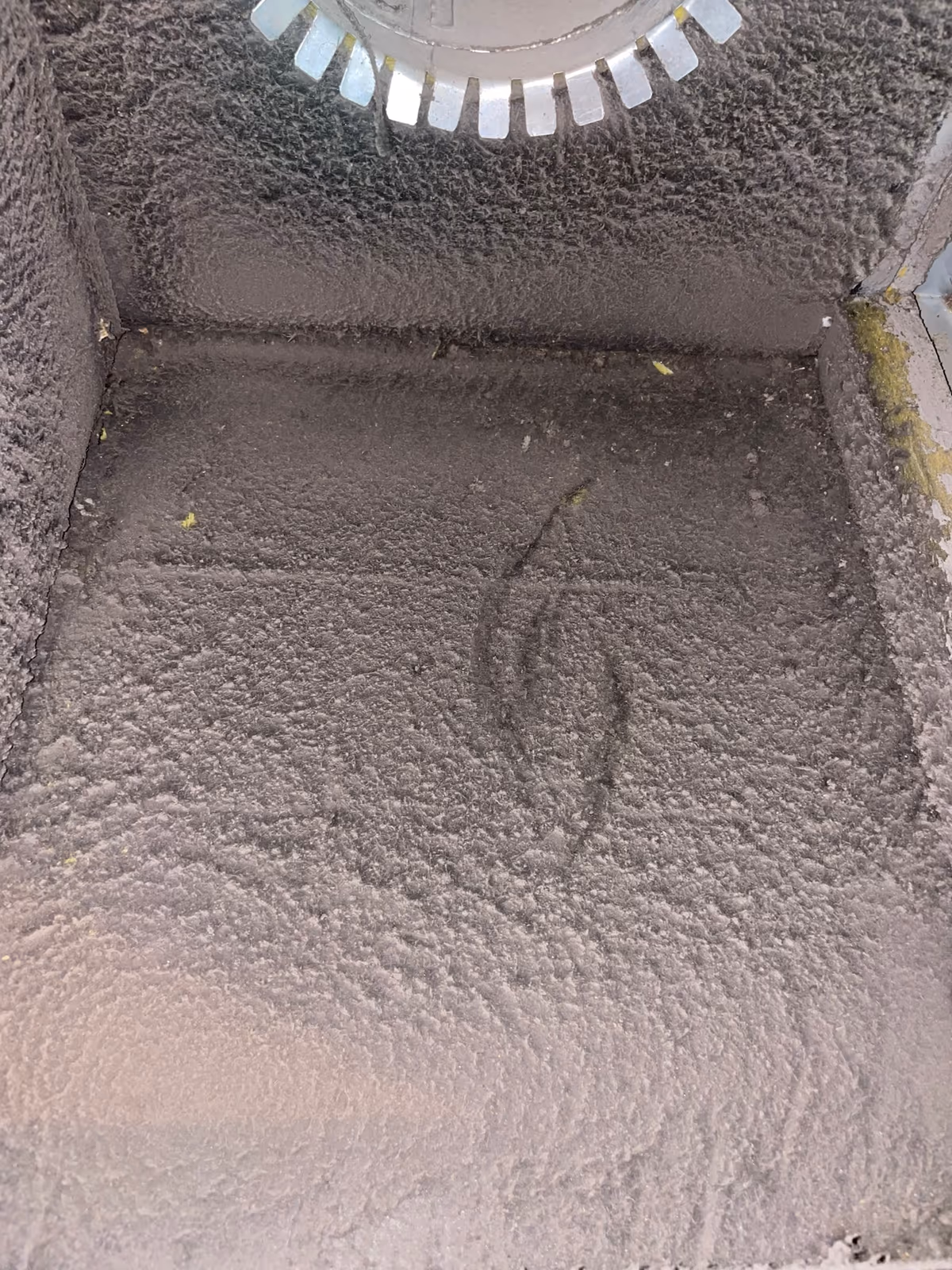 Dust and debris built up across the floor of a supply plenum before Floriduct cleaned it