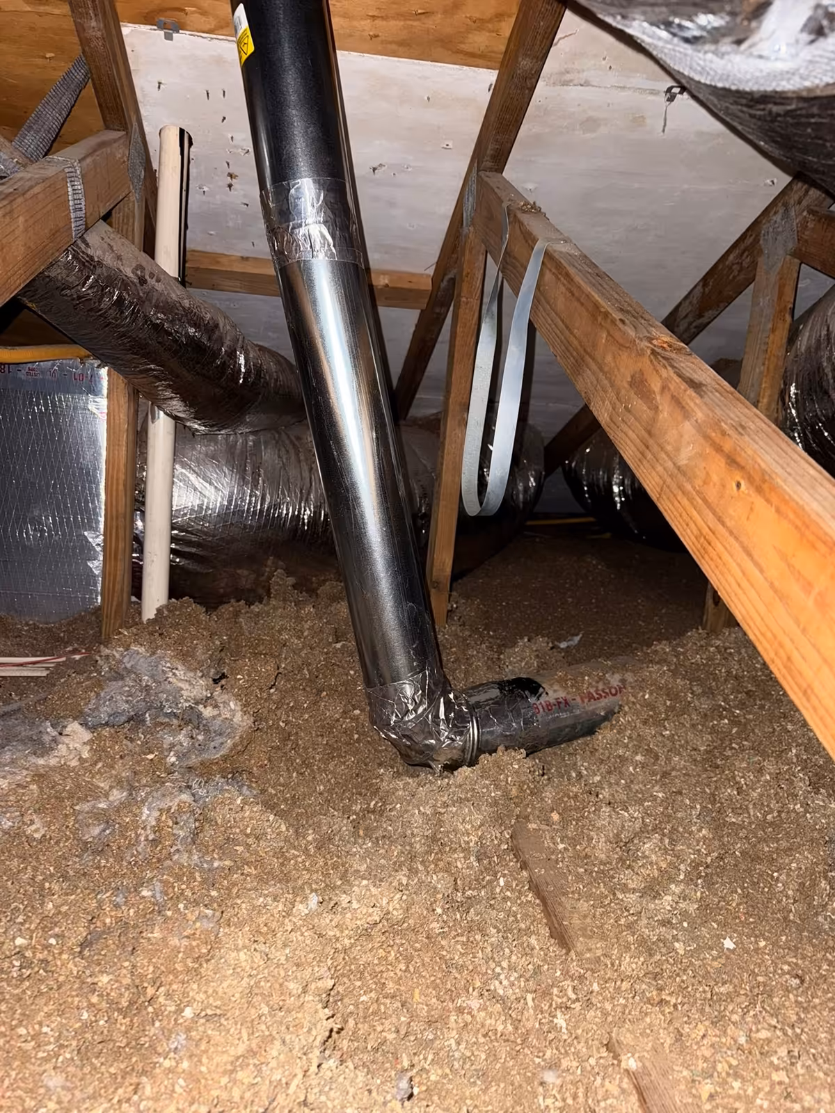 New rigid metal dryer duct run installed in an attic, taped at the joints and connected down to the existing flexible line